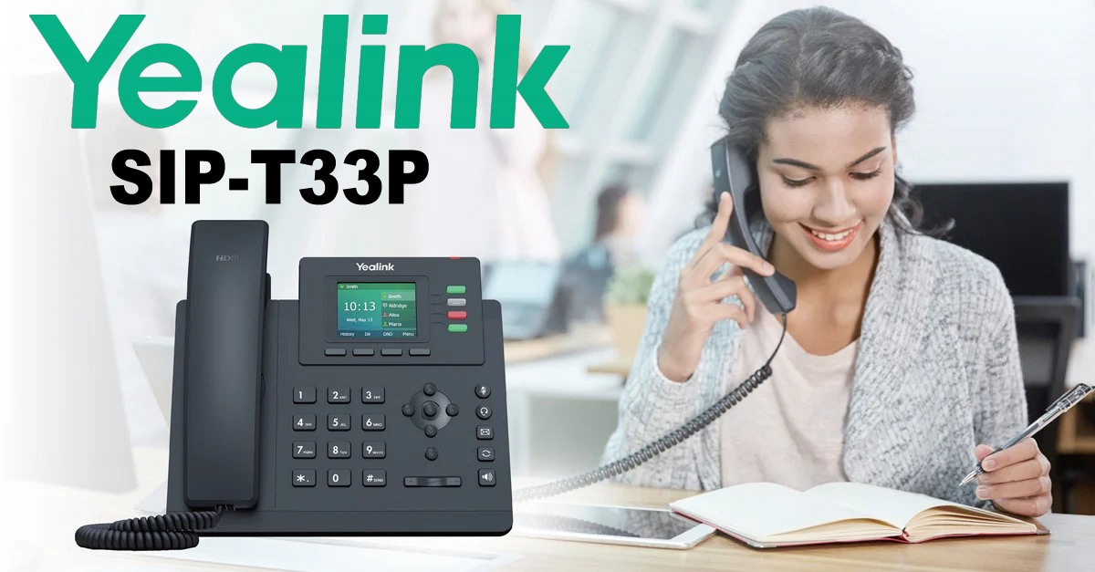 A smiling woman using the Yealink SIP-T31P desk phone while taking notes with an open book in front of her.