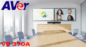 Modern conference room featuring the AVer VB 370A, with two displays showing collaborative video participants and a sleek wooden table.